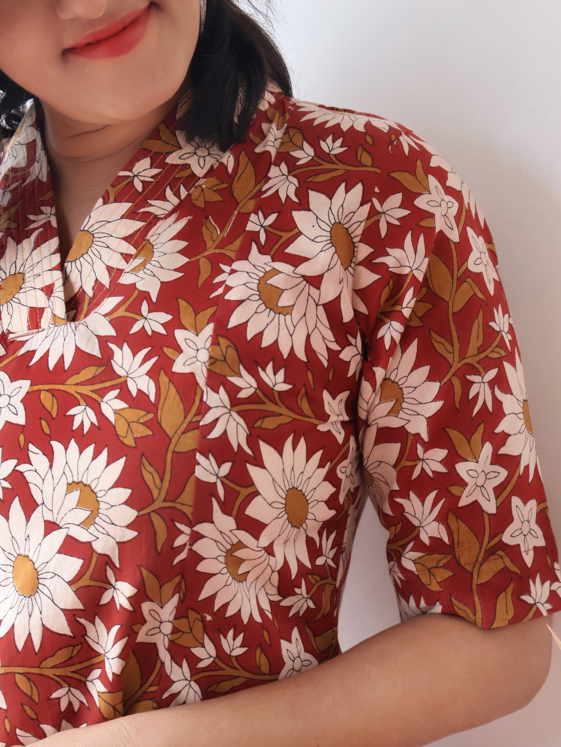 Reddish Gerbera Bagru hand block printed kurta in 100% pure cotton, featuring white floral motifs, panel A-line silhouette, collar V-neck, elbow sleeves, and a side pocket—crafted for breathable comfort and timeless everyday elegance.