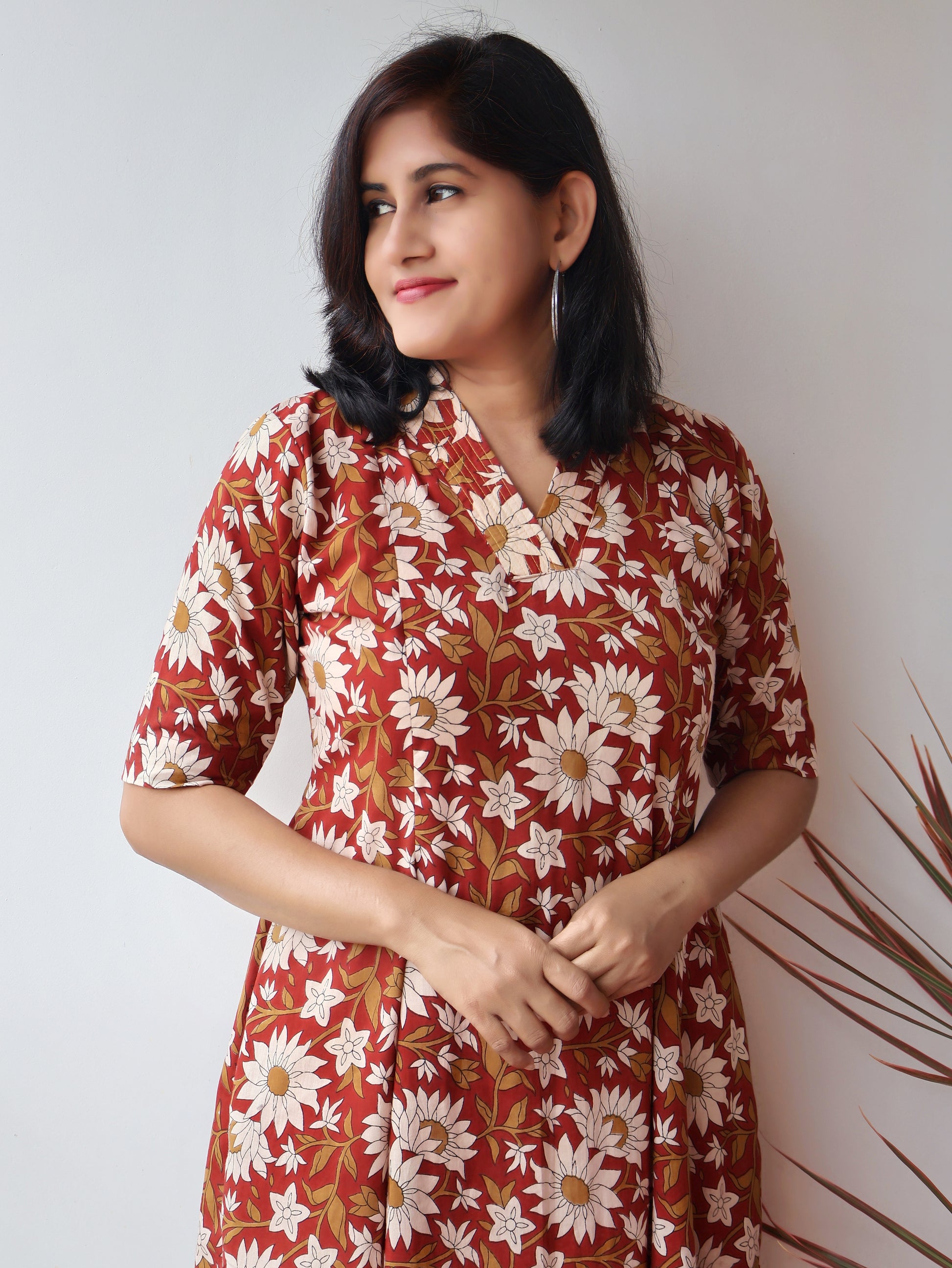 Reddish Gerbera Bagru hand block printed kurta in 100% pure cotton, featuring white floral motifs, panel A-line silhouette, collar V-neck, elbow sleeves, and a side pocket—crafted for breathable comfort and timeless everyday elegance.