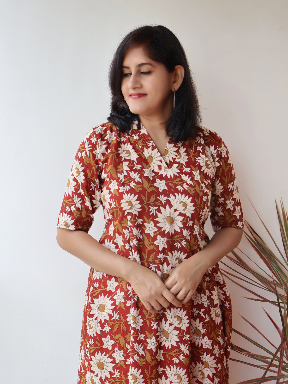 Reddish Gerbera Bagru hand block printed kurta in 100% pure cotton, featuring white floral motifs, panel A-line silhouette, collar V-neck, elbow sleeves, and a side pocket—crafted for breathable comfort and timeless everyday elegance.
