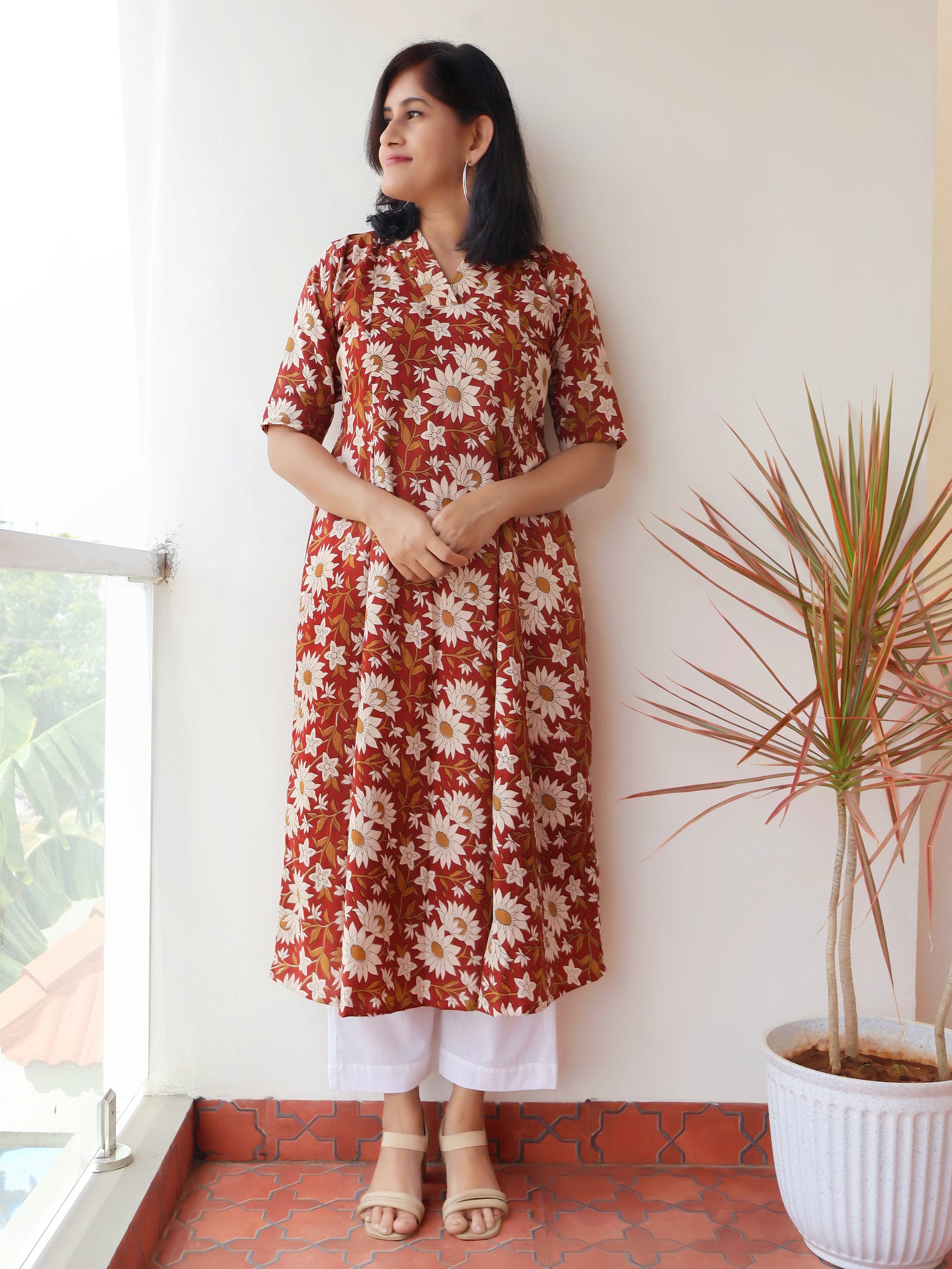 Reddish Gerbera Bagru hand block printed kurta in 100% pure cotton, featuring white floral motifs, panel A-line silhouette, collar V-neck, elbow sleeves, and a side pocket—crafted for breathable comfort and timeless everyday elegance.
