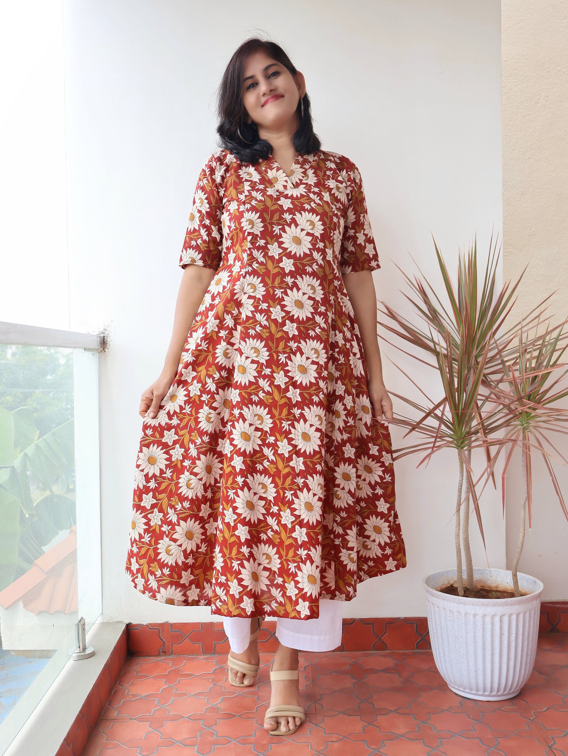 Reddish Gerbera Bagru hand block printed kurta in 100% pure cotton, featuring white floral motifs, panel A-line silhouette, collar V-neck, elbow sleeves, and a side pocket—crafted for breathable comfort and timeless everyday elegance.