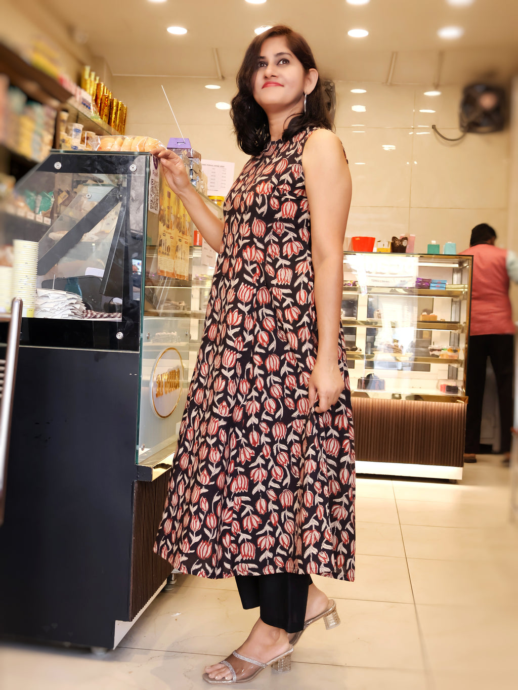Woman in a stylish sleeveless bagru hand block kurta & standing in a cafe shop