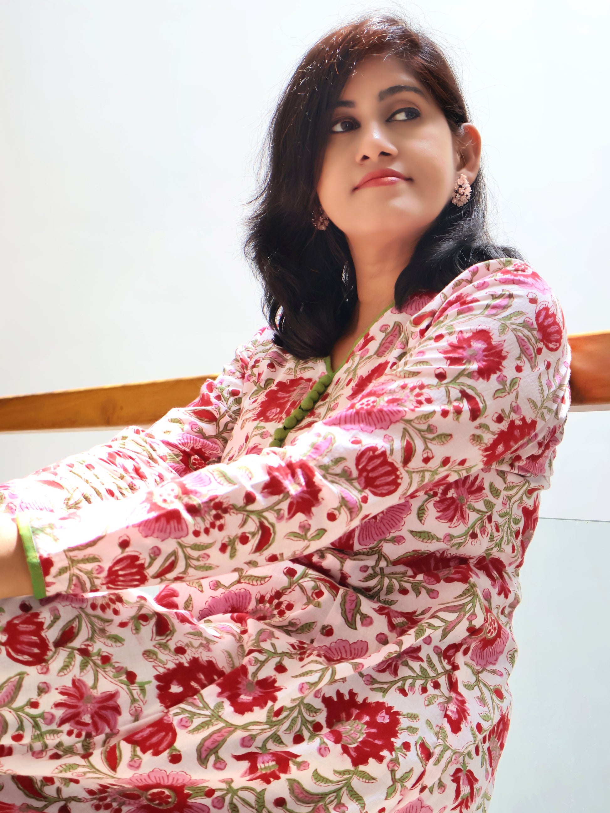 Women wearing Pink cotton kurta with curve V-neck and contrast green handwork