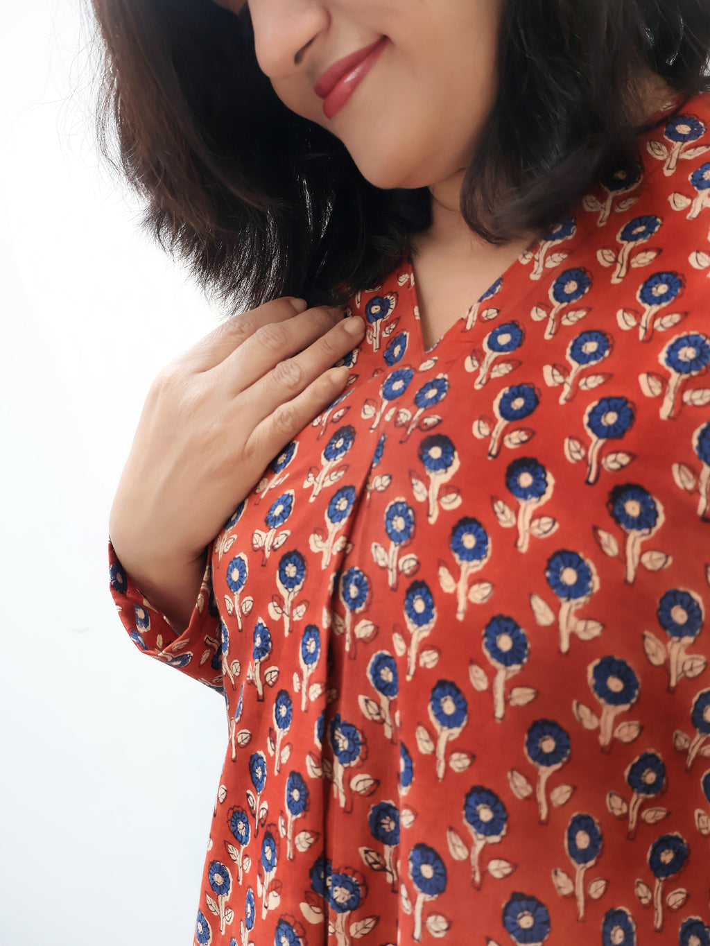 Woman wearing a red floral-patterned kurta on a white background