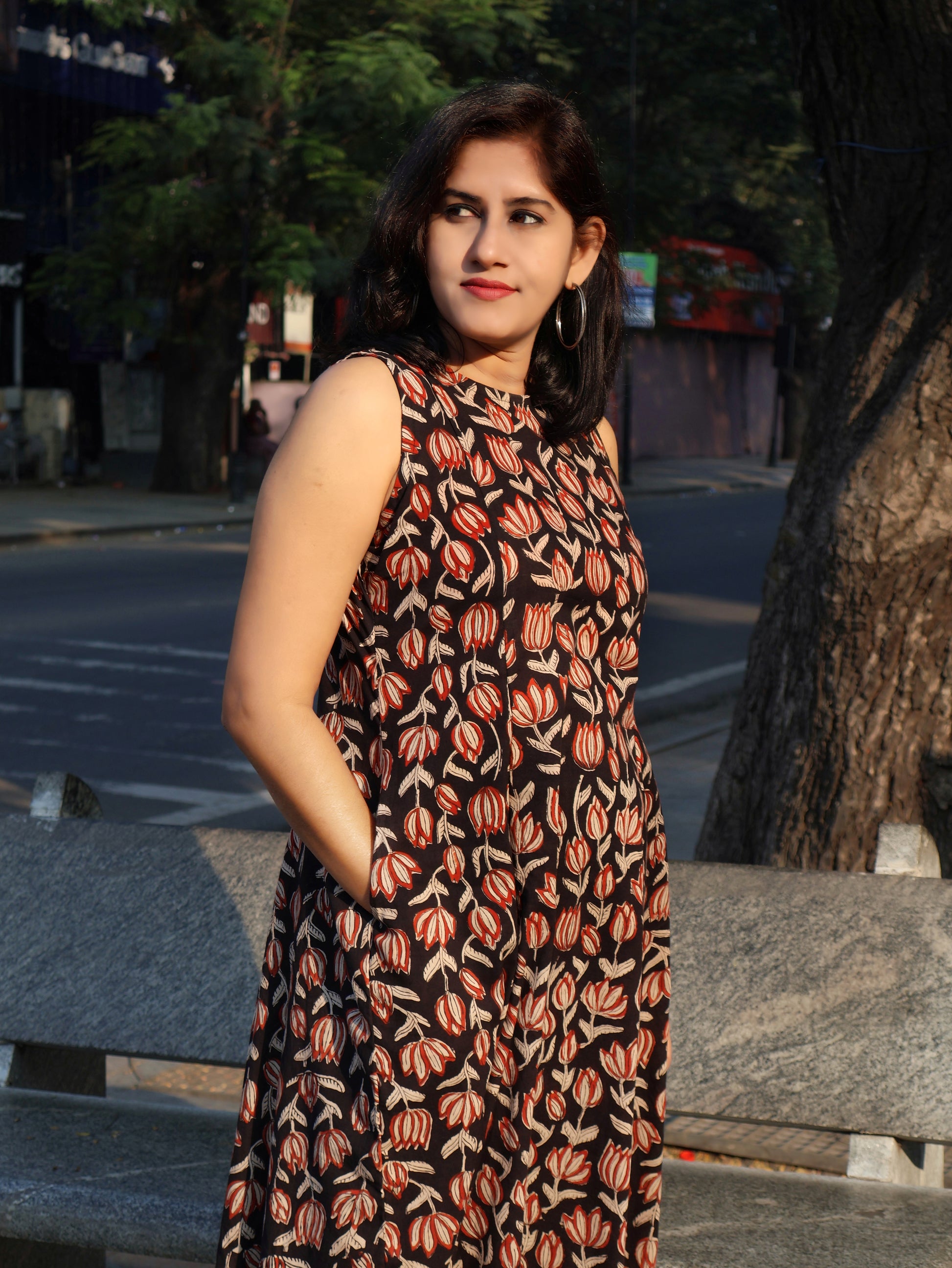 Woman in a floral bagru hand block printed kurta, standing outdoors near a tree