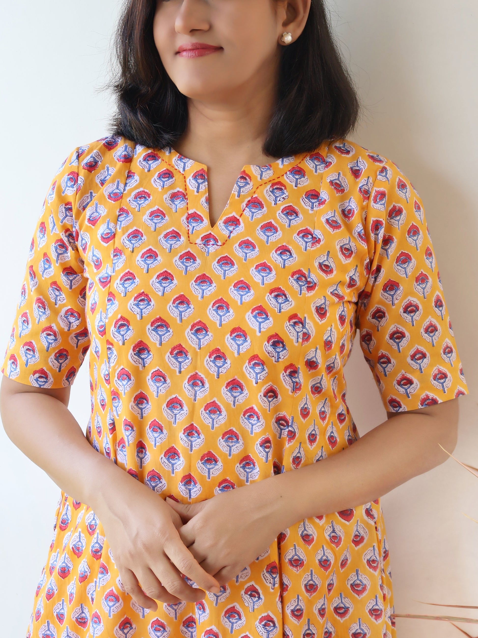 Detail shot of red butti Sanganeri hand block print on yellow pure cotton kurta