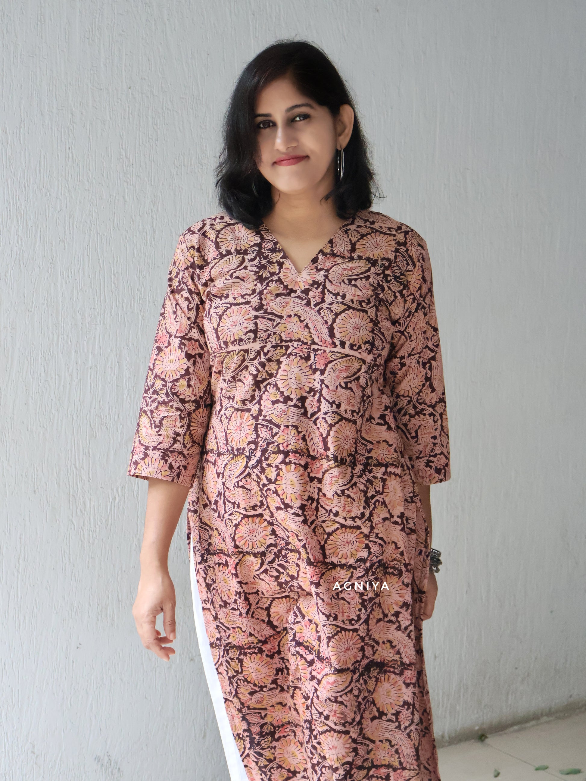 Woman wearing a kalamkari kurta in a plain background