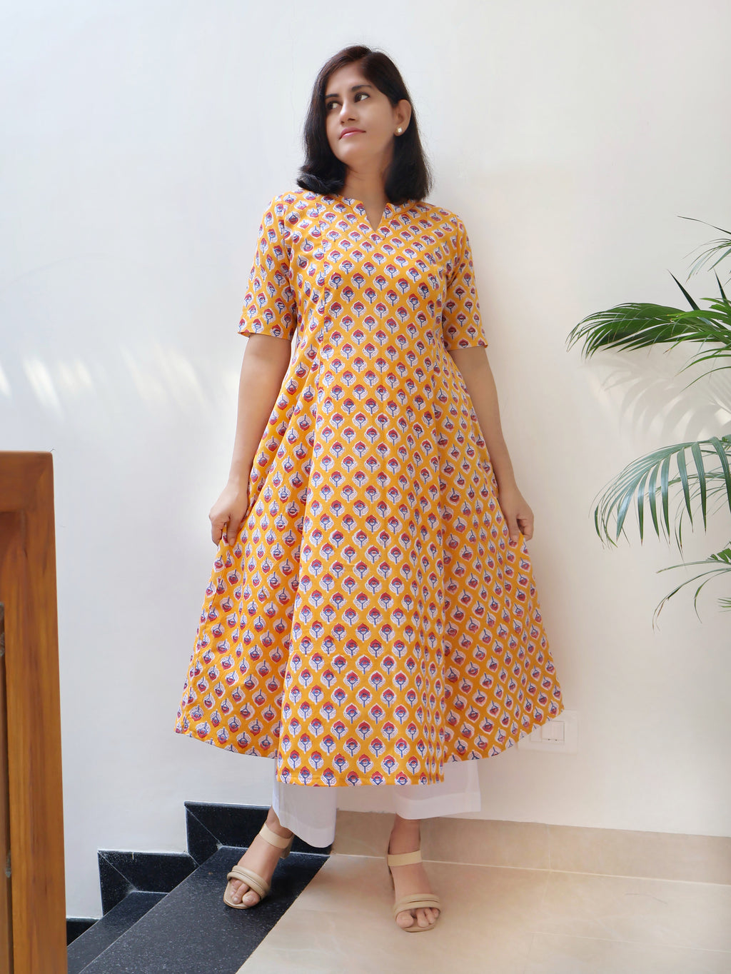 Yellow paneled A-line kurta in Sanganeri hand block print with hand embroidery at neckline